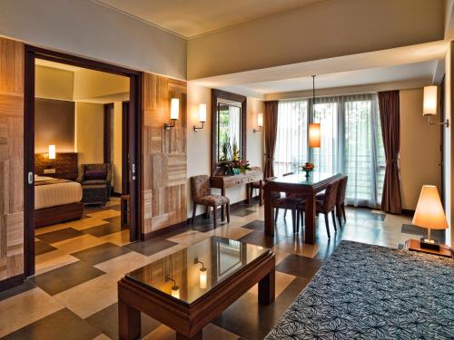 a living room with a table and a bedroom at Sun Island Hotel & Spa Kuta in Kuta