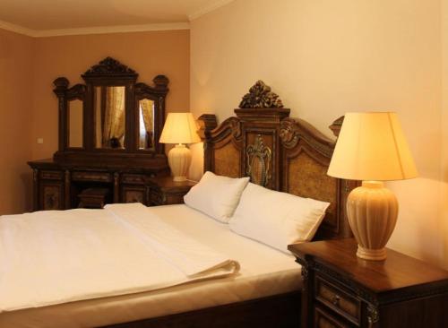 a bedroom with a bed with two lamps on a table at Teplice Plaza in Teplice