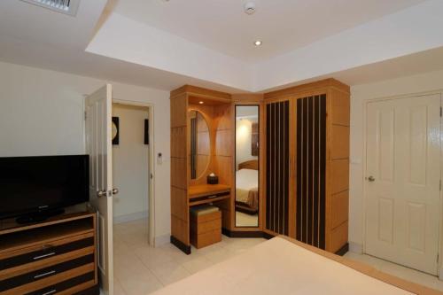 Habitación con 1 dormitorio con 1 cama y TV. en Royal Park Apartments en Jomtien Beach
