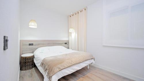 a small white bedroom with a bed in it at Cambrils 4 in Cambrils