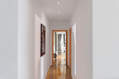a hallway with white walls and a wooden floor at Su Jiu Apartment in Nanning