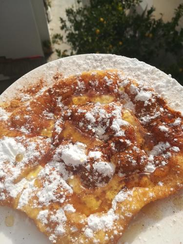 a pizza with powdered sugar on top of it at Villa Mikra Asia in Poros