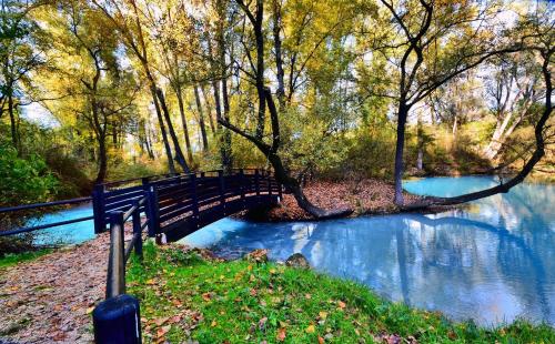 a bridge over a river with trees and water at Il Rifugio dei Briganti in Caramanico Terme
