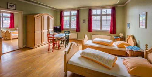 um quarto com três camas e uma mesa e cadeiras em Gasthof Zur Traube em Roggwil