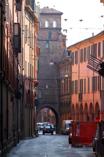 uma rua da cidade com um edifício com um túnel em University beb bologna em Bolonha