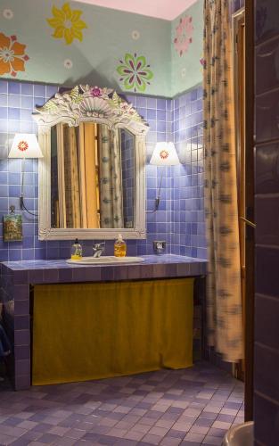 uma casa de banho em azulejos azuis com um lavatório e um espelho em University beb bologna em Bolonha