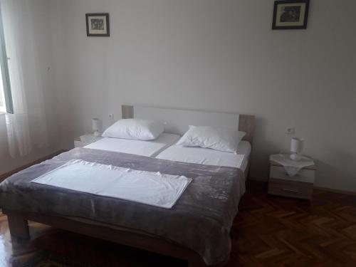 1 dormitorio con 1 cama con sábanas y almohadas blancas en Apartment Tin, en Senj
