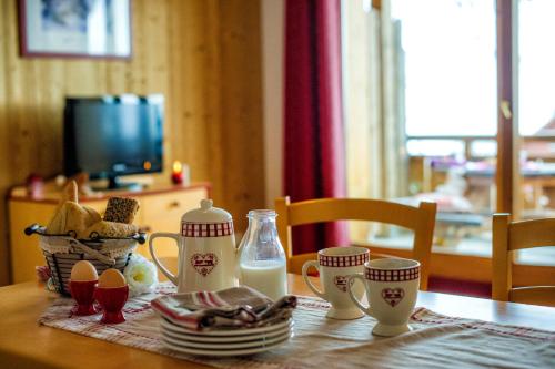 une table avec des œufs et du lait sur une table dans l'établissement Résidence Goélia Les 4 Vallées, à Saint-François-Longchamp