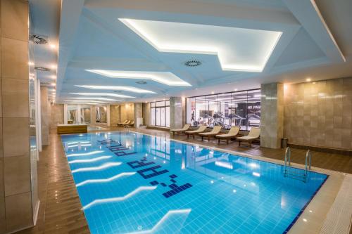 uma grande piscina no átrio do hotel com cadeiras em Karpalas City Hotel & Spa em Bolu