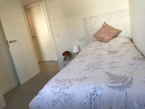 a bedroom with a bed with a pink pillow on it at Domus Aurea in Palamós