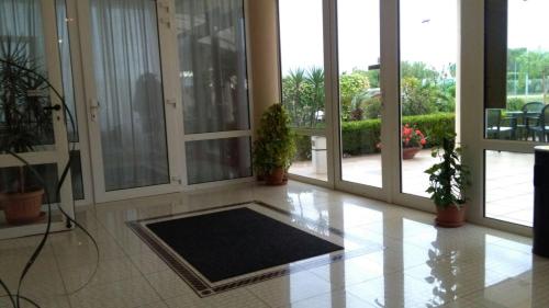 a lobby with a large room with doors and plants at Hotel Minerva in Brindisi