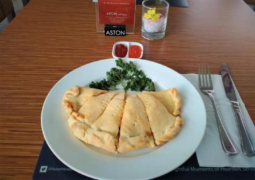 a white plate with a pie on a table at Aston Lampung City Hotel in Bandar Lampung