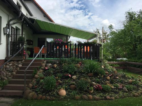Brieselang的住宿－Landhotel "Zum ersten Siedler"，一座带围栏的房屋前的花园