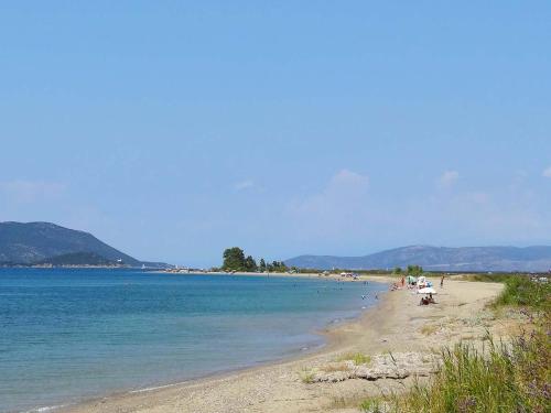 a beach with people sitting on the sand and the water at Chroma Studios in Oreoí