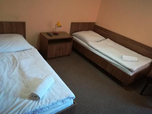 una camera con due letti e un tavolo con una lampada di Hotel Polonia a Nowa Sól