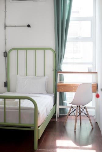 a bedroom with a bed and a desk and a chair at Memmoth Hostel In Lampang in Lampang