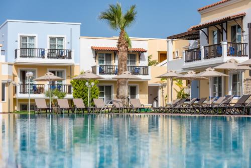a hotel swimming pool with chairs and umbrellas at Aegean Houses in Kos