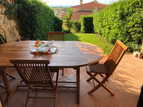 サン・テオドーロにあるresidenza Gli Asparagiの木製テーブルと椅子付きのパティオ