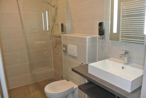 a bathroom with a sink and a toilet and a shower at Best Western Hotel Den Haag in The Hague
