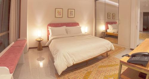 um quarto com uma cama e uma secretária com um telefone em Bungalow 99 em Nova Deli