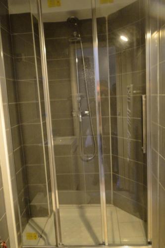une douche avec une porte vitrée dans une salle de bain dans l'établissement Appartement ENTRE TROCADERO et CHAMPS ELYSES, à Paris
