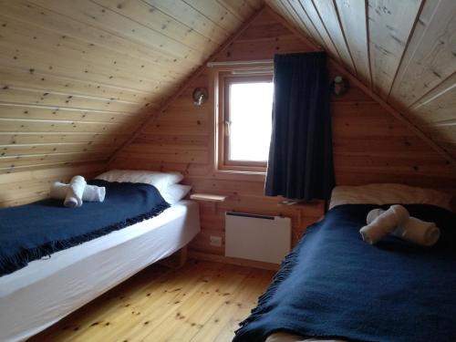 um quarto com 2 camas num chalé de madeira em Adventure Camp Mehamn em Mehamn