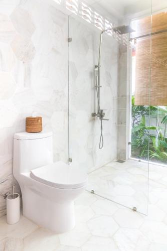 a white bathroom with a shower and a toilet at Jasmine Garden in Hoi An