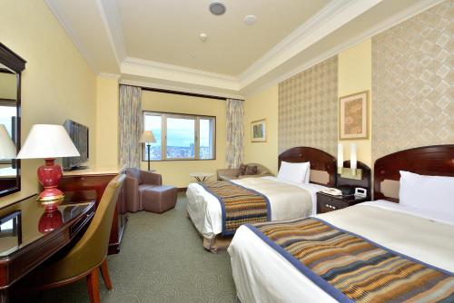 A bed or beds in a room at Okinawa Kariyushi Urban Resort Naha