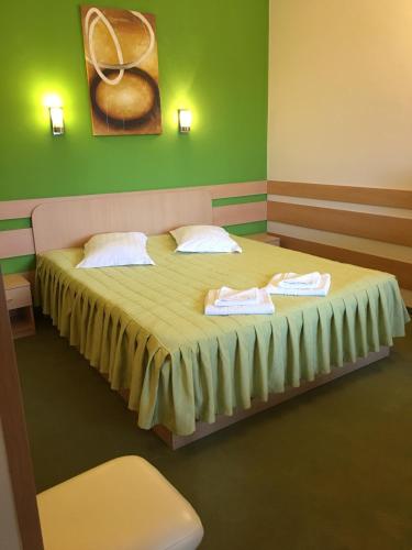 a bedroom with a bed with two towels on it at Motel Sora in Sovata
