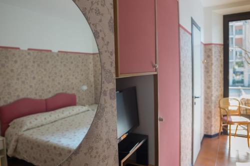 a bedroom with a bed and a pink cabinet at Hotel Locanda Mel in Calolziocorte