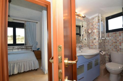 a bathroom with a sink and a toilet and a bed at Elios Villa Chalkidiki in Skala Fourkas
