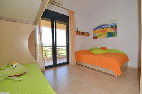 a bedroom with an orange bed and a balcony at Elios Villa Chalkidiki in Skala Fourkas