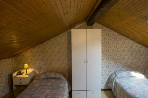 two beds in a room with a wooden ceiling at Hotel Locanda Mel in Calolziocorte