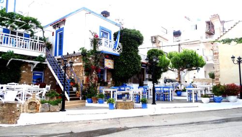 a building with blue tables and chairs on a street at Malia Boutique Studios in Malia