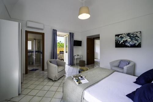 a bedroom with a large bed and two chairs at Casa Assunta B&B in Vico Equense