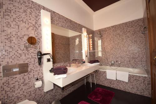 uma casa de banho com um lavatório, uma banheira e um espelho. em Alte Rentei em Schleiden