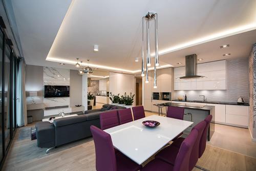 cocina y sala de estar con mesa y sillas moradas en NordicHaven Apartments, en Bydgoszcz