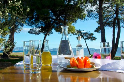 a table with glasses and a plate of fruit and bottles at Makis Inn Resort in Thermisía