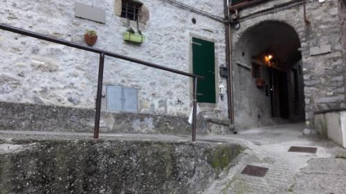 an alley with a green door in a stone building at Casa Quaratica in Riccò del Golfo di Spezia