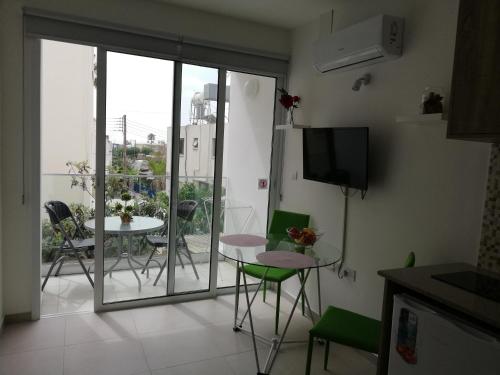 a living room with a balcony with a table and chairs at Chicos Studios in Ayia Napa