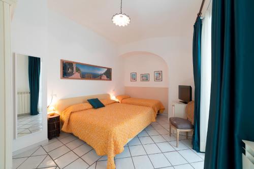 um quarto com duas camas e uma televisão em Mimì B&B em Ravello