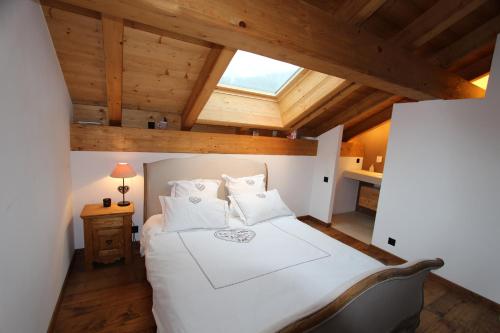 a bedroom with a white bed in a attic at La Montagne in Chateau-d'Oex