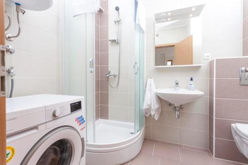 y baño con lavadora y lavamanos. en Apartments Dora en Makarska