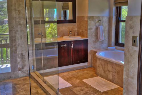 a bathroom with a shower and a tub and a sink at Villa Seaview in Knysna