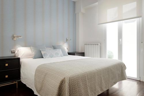 ein Schlafzimmer mit einem großen Bett mit einer weißen Decke in der Unterkunft Marina by FeelFree Rentals in San Sebastián