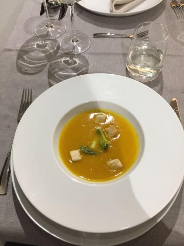 a white plate with a bowl of soup on a table at Boutique Hotel Corso in Karlovy Vary