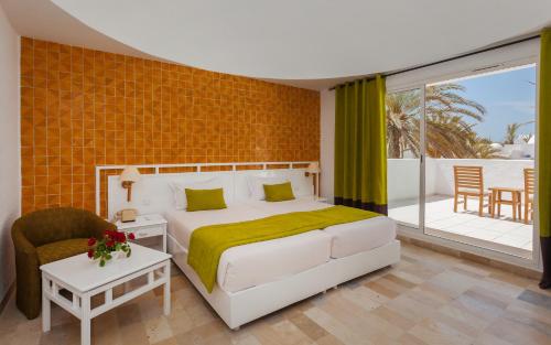 a bedroom with a bed and a balcony at El Mouradi Djerba Menzel in Midoun