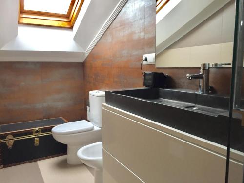 uma casa de banho com um lavatório e um WC em Ático Marqués Playa Centro - garaje opcional em Gijón
