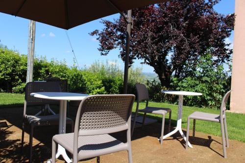 a table and chairs sitting under an umbrella at Ellebì B&B in Montone
