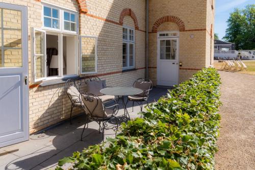 a patio with a table and chairs in front of a building at Kokkedal Slot Copenhagen in Hørsholm